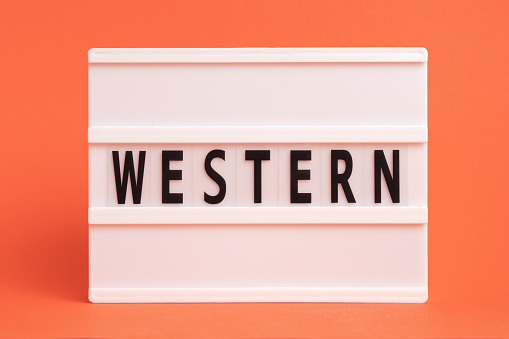 The word western on lightbox isolated orange background. Literary Genres