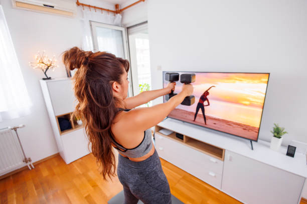 istock Woman working out with dumbbells at home 1560551439