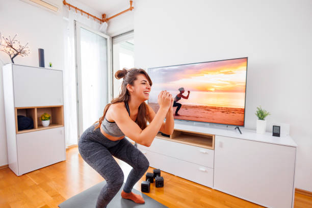 istock Woman doing squats while working out at home 1560554650