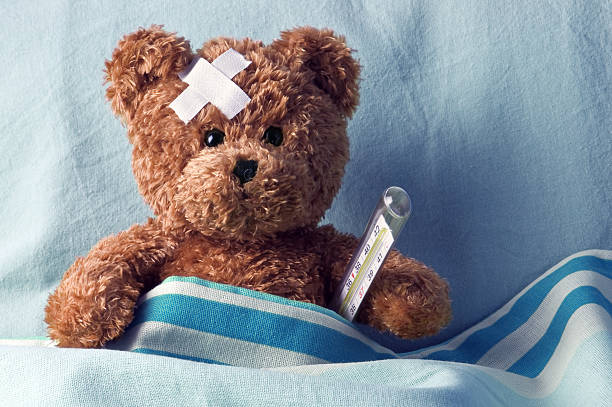 bear bear in bed with thermometer and plaster teddy bear stock pictures, royalty-free photos & images