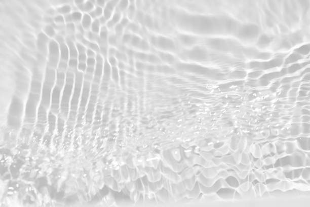 istock White water with ripples on the surface. Defocus blurred transparent white colored clear calm water surface texture with splashes and bubbles. Water waves with shining pattern texture background. 1560601445