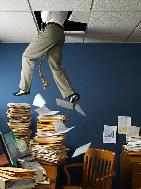 Businessman escaping work through ceiling.