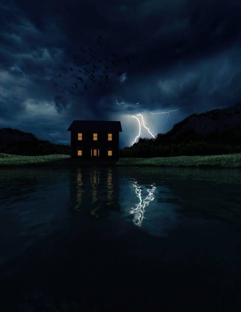 istock House with lit windows at a mountain lake with a lightning strike in a dark cloudy sky. 3D render. 1560624802
