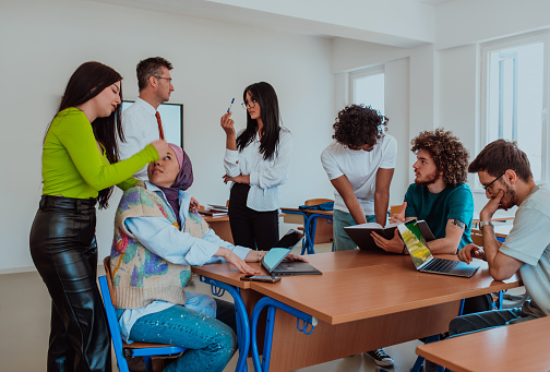 A diverse group of students gathers in a modern school classroom, passionately engaging in lively discussions about various projects, embracing teamwork and utilizing technology to enhance their learning experience.