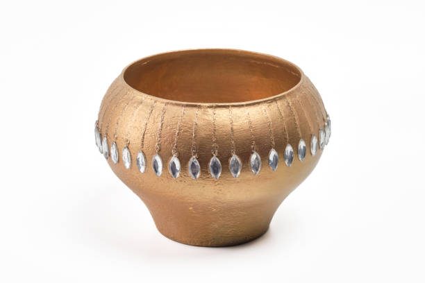 Golden pottery, clay isolated on white background. Handmade vase made of silver glass shards or jewelry stones.