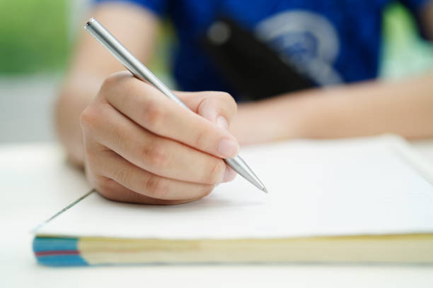 istock Asian teenage student write homework, study lesson for exam online learning education. 1560657392