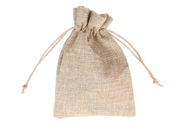 istock Burlap gift bag with golden coins isolated on white background 1560665677