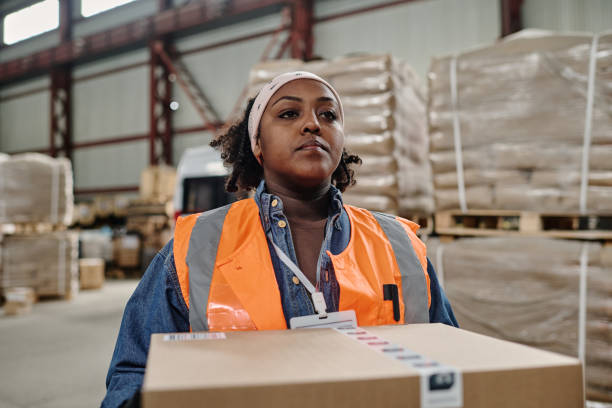istock Female worker carrying box in warehouse 1560668438