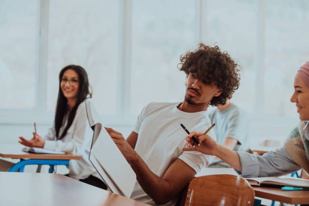 istock A group of diverse students engages in lively discussion as they educate themselves in a modern classroom, embracing the power of collaboration and knowledge exchange. 1560681944
