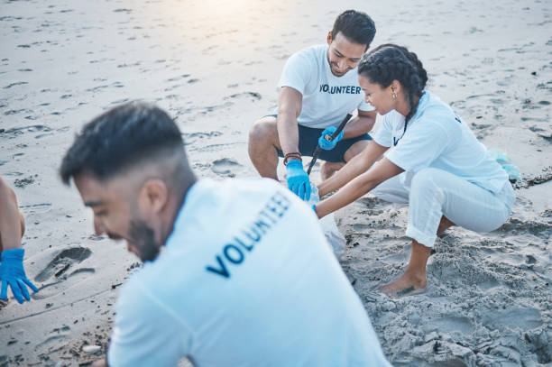 istock Charity, teamwork and cleanup at beach for recycling in environment with help for community. Volunteers, together and ocean or sand with cleaning, pollution and eco friendly service in nature. 1560707140