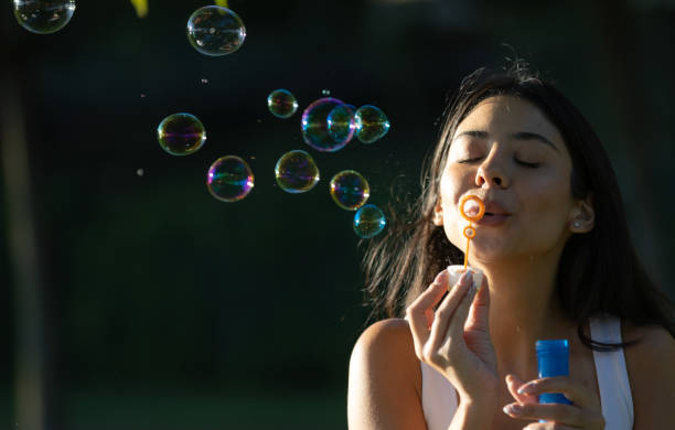 istock Young woman is  blowing bubbles on the outside. 1560737372