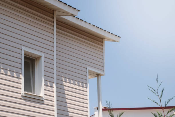 a fachada da nova casa revestida de tapumes, com janelas, contra o céu azul. - siding house plastic roof - fotografias e filmes do acervo