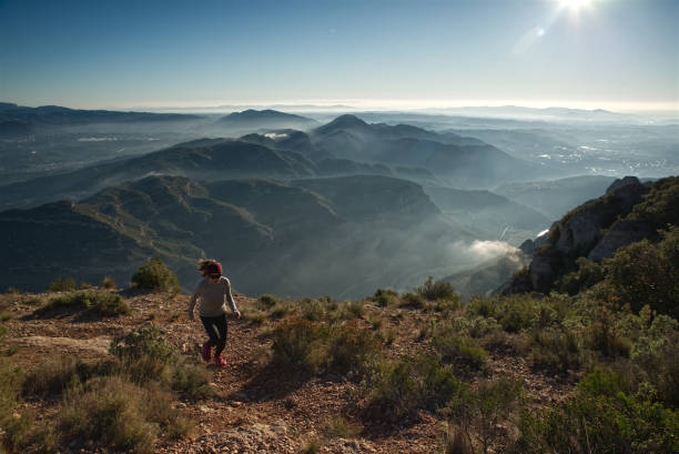 Female athlete runs through the mountains of Montserrat in Catalonia, Spain.