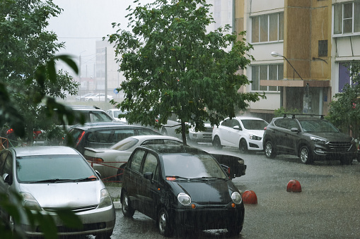 Cars parked in the yard under a heavy downpour