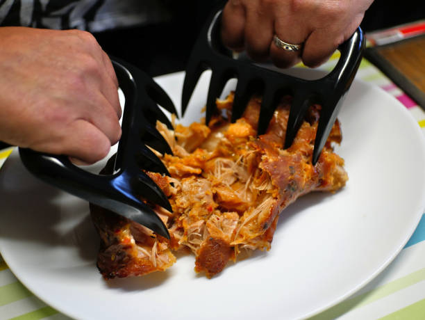 Shredding of pork roast (with claws), in preparation for pulled pork