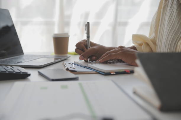 istock Asian Businesswoman Using laptop computer and working at office with calculator document on desk, doing planning analyzing the financial report, business plan investment, finance analysis concept. 1560831360