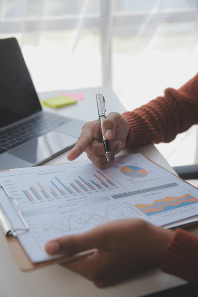 istock Asian Businesswoman Using laptop computer and working at office with calculator document on desk, doing planning analyzing the financial report, business plan investment, finance analysis concept. 1560836363
