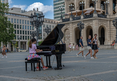 frankfurt am main, germany-july 14, 2023: Young piano player in front of the Alte Oper, Frankfurt, Germany