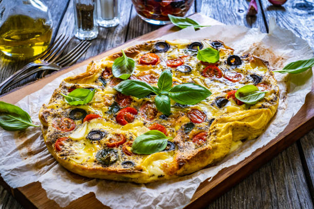 istock Frittata - scrambled eggs with mozzarella and vegetables on wooden table 1561017472