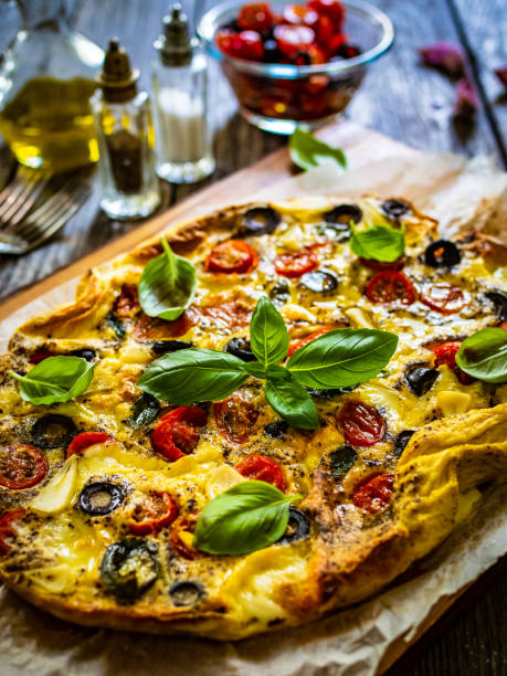 istock Frittata - scrambled eggs with mozzarella and vegetables on wooden table 1561017505