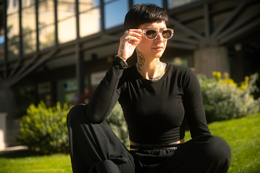 Beautiful woman with short hair portrait outdoor in the city wearing sunglasses