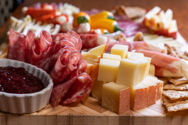 The well-stocked charcuterie board delights with a variety of cheeses, meats, and a heavenly baked brie, a true culinary treasure. The well-stocked charcuterie board is a tapestry of culinary delights, showcasing an extensive selection of cheeses and meats. From velvety triple-cream brie to aged gouda and spicy pepper jack, the cheese assortment caters to all palates. Cured meats, such as smoky bacon and tangy salami, add savory notes to the ensemble. The centerpiece, a beautifully baked brie, entices guests with its inviting aroma and creamy texture. This symphony of flavors presents a tantalizing experience, allowing guests to explore the world of cheese and meats with each sumptuous bite. prosciutto brie stock pictures, royalty-free photos & images