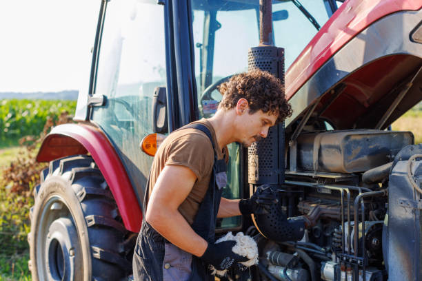 Pre-harvest Tractor Inspection A farmer or mechanic performs routine maintenance on his tractor before harvest. agriculture equipment stock pictures, royalty-free photos & images