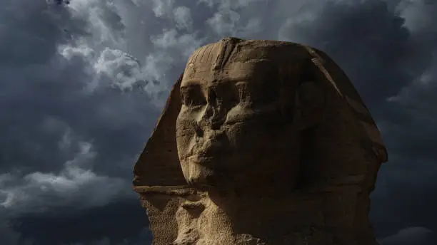 Photo of Sphinx head and dark storm clouds