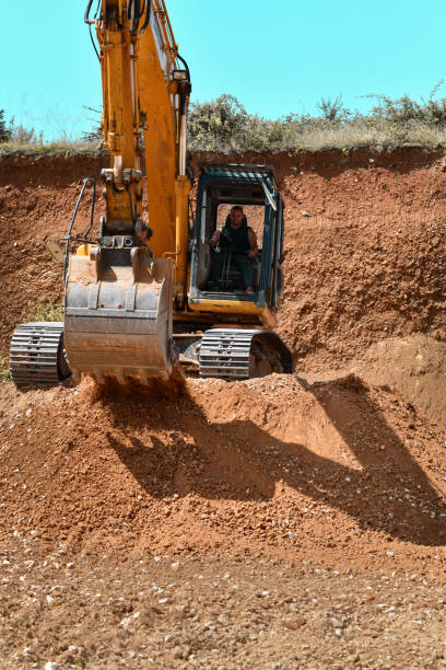 istock Front View Of Male Worker Operating Heavy Machinery On Site 1561102963