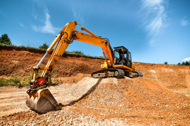 istock Blue Sky On A Hot Summer Day While Worker Is Operating Heavy Excavator On Construction Site 1561103489
