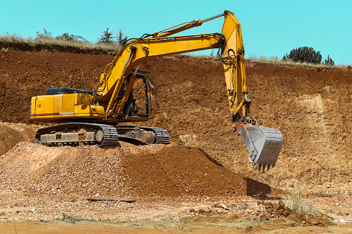 Enormous Excavator Parked On Dirt Mound While Digging Out More