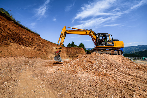 Construction Site Preparation By Worker With Excavator