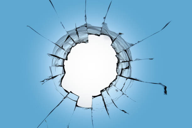 istock A big hole in the blue sky. Cracks on the window from breaking. 1561125243