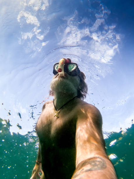 istock Man on vacation snorkeling in the water. Underwater view. 1561127492