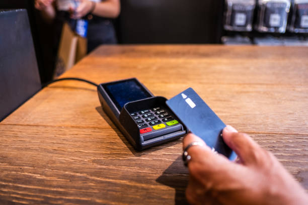 istock Paying for a purchase with a bank card at a store's POS terminal. 1561147787