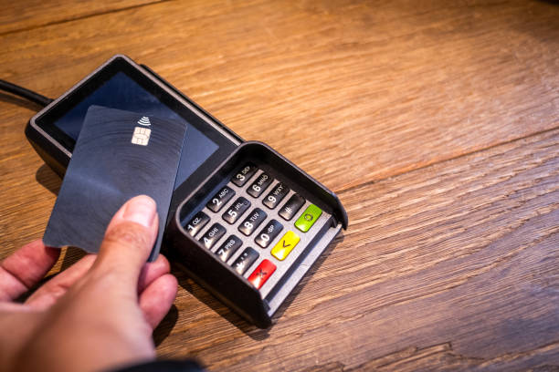 istock Paying for a purchase with a bank card at a store's POS terminal. 1561147790