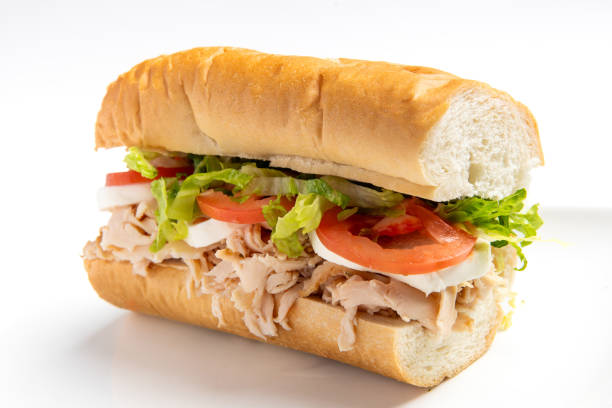 Sliced Turkey, Mozzarella, lettuce and tomato submarine sandwich on white background