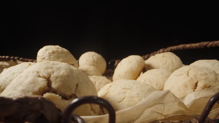 Round homemade oatmeal cookies in a wicker basket. on a black background. Dolly slider extreme close-up.