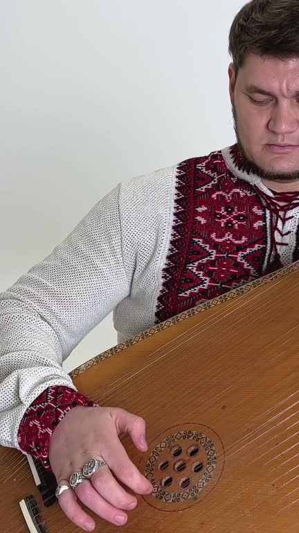 musician in embroidery plays kobza close-up a handsome middle-aged man plays a musical ethnic Ukrainian instrument victory of Ukraine independence and invincibility glory to Ukraine glory to heroes