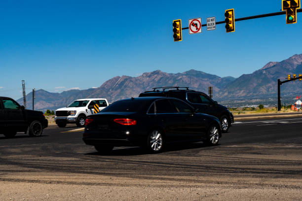 istock Vehicles flow through suburban intersection on sunny summer day. A sprawling city stretches with majestic mountains in the distance. 1561244522