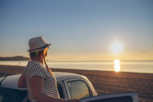 istock Woman looking at sunset at the beach 1561266381