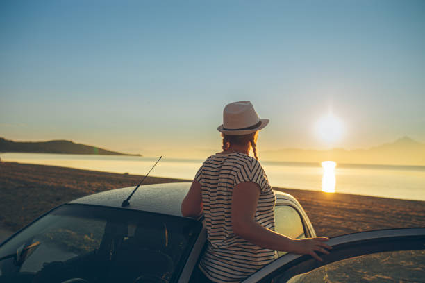 istock Woman looking at sunset at the beach 1561268515