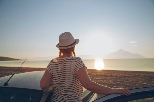 istock Woman looking at sunset at the beach 1561269039
