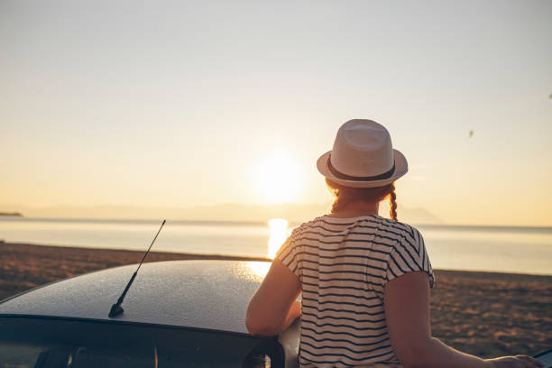 istock Woman looking at sunset at the beach 1561270064