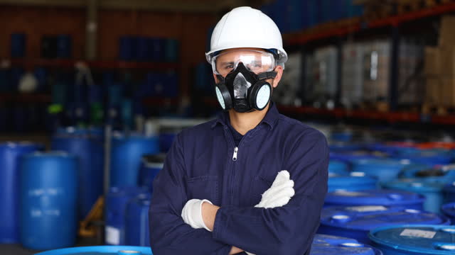 Portrait of a Latin American man working at a chemical plant wearing protective workwear crossing arms while facing the camera