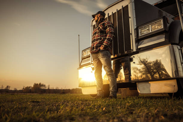 Trucker in Front of His Semi Truck During Sunset stock photo