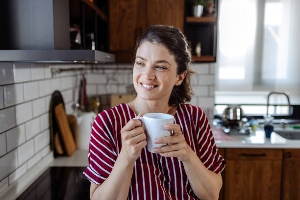 istock Morning Bliss: woman savouring coffee with a smile 1561377892