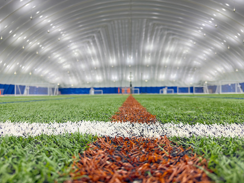 Wide angle view of an empty American football practice field on a summer day