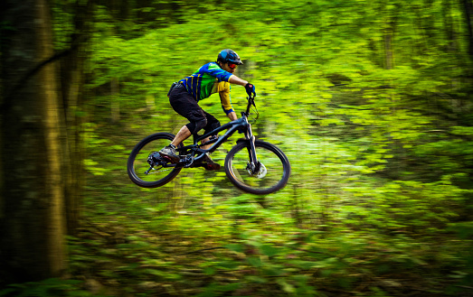 Cross-country downhill rider taking a high jump stunt