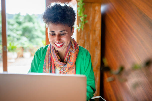 istock Smiling woman using a laptop while working at home 1561425822